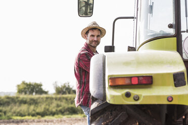 Porträt eines selbstbewussten Landwirts mit Traktor - UUF11922