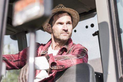 Portrait of confident farmer on tractor stock photo