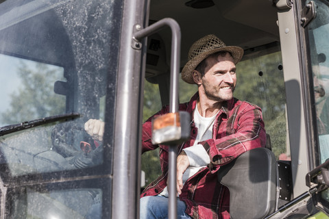 Smiling farmer on tractor stock photo