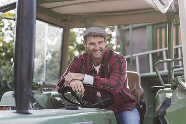 Portrait of confident farmer on tractor - UUF11939