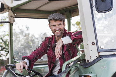 Porträt eines selbstbewussten Landwirts auf einem Traktor - UUF11940
