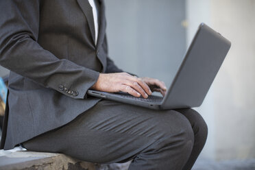 Businessman working on laptop outside - ZEF14646