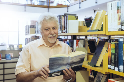 Porträt eines älteren Mannes in einer Stadtbibliothek, der ein Buch hält - FRF00569