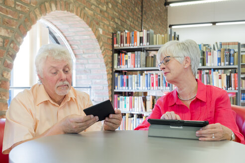 Älteres Paar mit Tablet und E-Book in einer Stadtbibliothek - FRF00579