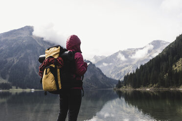 Austria, Tyrol, Alps, hiker standing at mountain lake - UUF11946