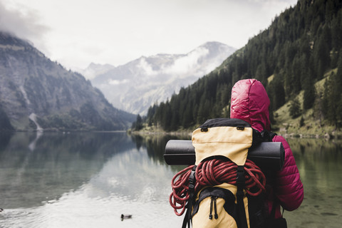 Austria, Tyrol, Alps, hiker standing at mountain lake stock photo