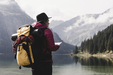 Austria, Tyrol, Alps, hiker standing at mountain lake - UUF11949