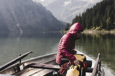 Österreich, Tirol, Alpen, Frau mit Rucksack in Boot auf Bergsee - UUF11950