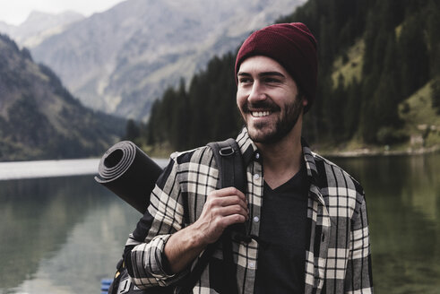 Österreich, Tirol, Alpen, Porträt eines lächelnden Mannes am Bergsee - UUF11969
