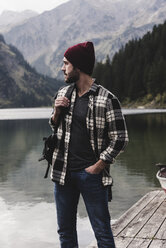 Austria, Tyrol, Alps, man standing on jetty at mountain lake - UUF11971