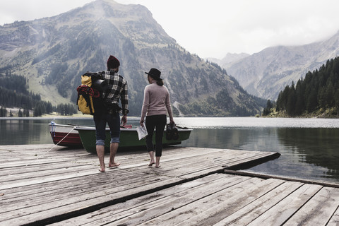 Österreich, Tirol, Alpen, Paar geht auf Steg an Bergsee, lizenzfreies Stockfoto