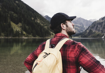 Austria, Tyrol, Alps, rear view of hiker at mountain lake - UUF11985