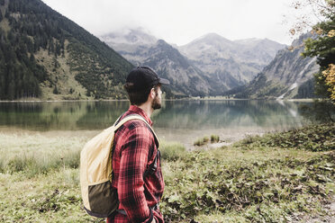 Austria, Tyrol, Alps, hiker standing at mountain lake - UUF11986