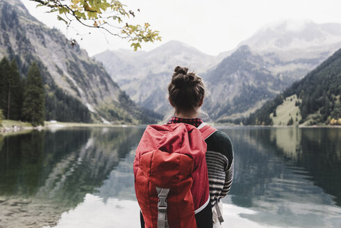 Austria, Tyrol, Alps, hiker standing at mountain lake - UUF11987