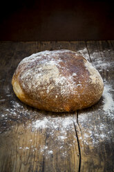 Wheat bread powdered with flour on dark wood - LVF06351