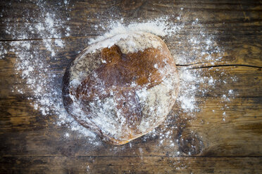 Mit Mehl bestäubtes Weizenbrot auf dunklem Holz - LVF06352