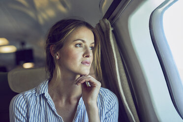 Ernste Frau schaut aus dem Flugzeugfenster - PNEF00213