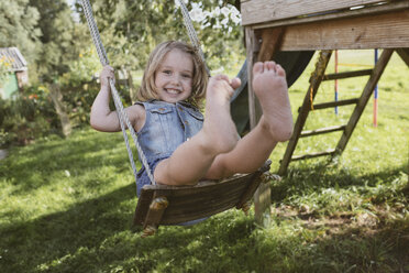 Happy little girl on swing in the garden - KMKF00022