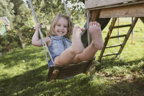 Happy little girl on swing in the garden - KMKF00022