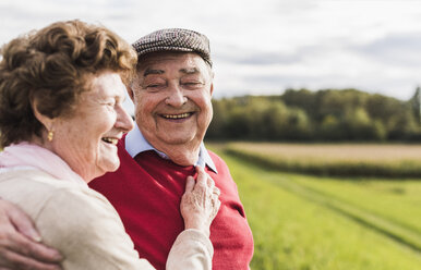 Happy senior couple embracing in rural landscape - UUF12036