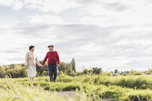 Älteres Paar bei einem Spaziergang in ländlicher Landschaft - UUF12039