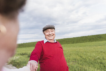 Happy senior man smiling at wife in rural landscape - UUF12055