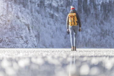 Deutschland, Berchtesgadener Land, Rückenansicht einer Frau mit Rucksack auf dem zugefrorenen Königssee - MMAF00152