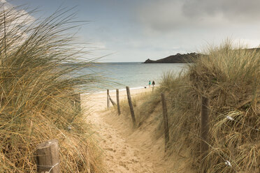 Frankreich, Bretagne, Blick auf das Meer mit Spaziergängern am Strand und Stranddünen im Vordergrund - FCF01285