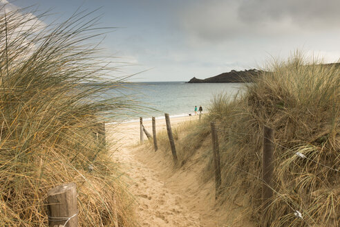 Frankreich, Bretagne, Blick auf das Meer mit Spaziergängern am Strand und Stranddünen im Vordergrund - FCF01285