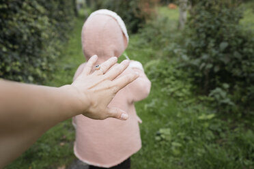 Die Hand der Mutter greift nach der Tochter im Garten - KMKF00030