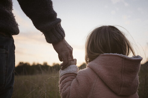 Vater mit Tochter stehen auf einem Feld bei Sonnenaufgang - KMKF00035