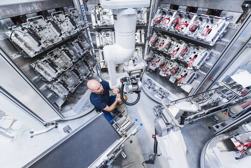 Mann arbeitet an einem Industrieroboter in einer modernen Fabrik - DIGF02932