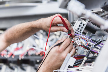 Nahaufnahme eines Mannes, der ein Voltmeter in einer Fabrik benutzt - DIGF02942