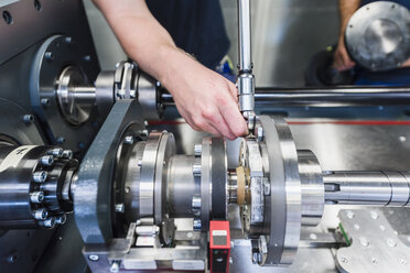 Close-up of man using screw wrench at a machine - DIGF02955