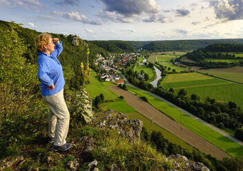 Deutschland, Bayern, Arnsberg, Seniorin schaut über Arnsberger Leite - SIEF07565