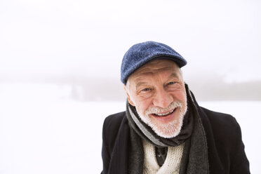 Portrait of laughing senior man in snow - HAPF02226