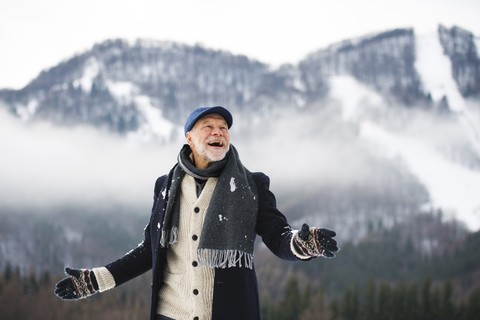 Porträt eines glücklichen älteren Mannes in einer Winterlandschaft, lizenzfreies Stockfoto