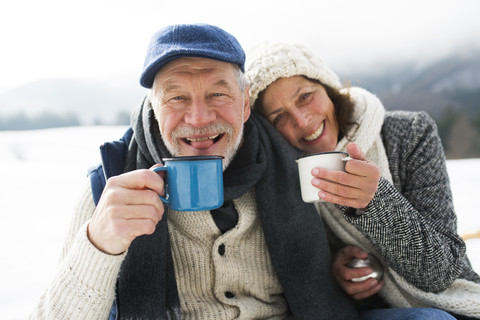 Porträt eines älteren Paares mit heißen Getränken im Winter, lizenzfreies Stockfoto