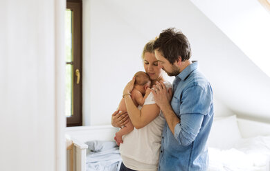 Eltern kuscheln mit kleinem Baby zu Hause - HAPF02276