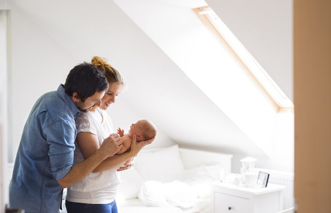 Eltern kuscheln mit kleinem Baby zu Hause, lizenzfreies Stockfoto