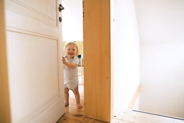 Porträt eines glücklichen kleinen Jungen, der die Tür öffnet - HAPF02289