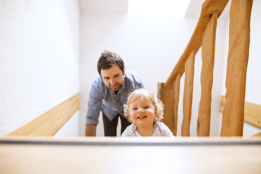 Vater mit kleinem Jungen auf Holztreppe zu Hause - HAPF02291