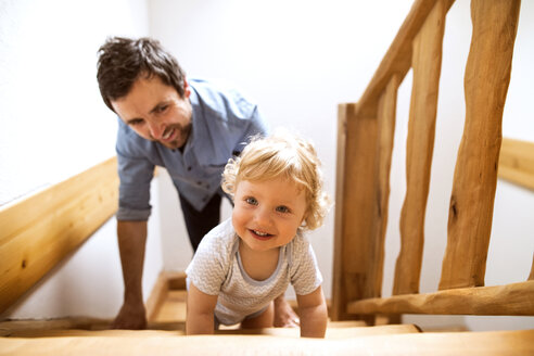 Vater mit kleinem Jungen auf Holztreppe zu Hause - HAPF02292