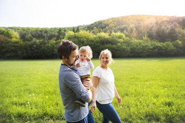 Parents walking with little boy on meadow - HAPF02306