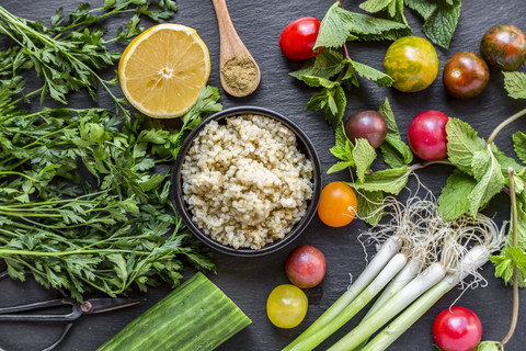 Bowl of Bulgur and ingredients for preparing Tabbouleh stock photo