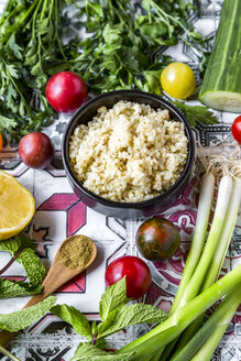 Schüssel mit Bulgur und Zutaten für die Zubereitung von Tabbouleh - SARF03388