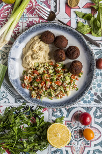 Bulgurweizensalat, Hummus und Falafel auf dem Teller - SARF03389