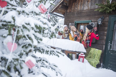 Austria, Altenmarkt-Zauchensee, female friends celebrating at wooden house at Christmas time - HHF05504