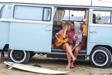 Junges Paar mit Gitarre und Surfbrett im Van am Strand - SIPF01812