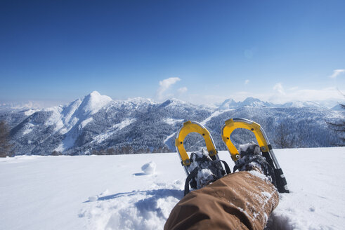 Austria, Salzburg State, Altenmarkt-Zauchensee, man with snowshoes lying in deep snow - HHF05507